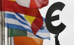 Euro symbol near European flags - Photo: REUTERS/Francois Lenoir