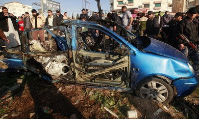 Palestinians look at the remains of exploded vehic