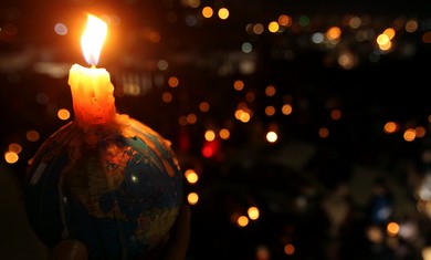 People hold candles during Earth Hour