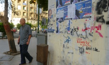 A man walks by a graffitied wall in DT Cairo