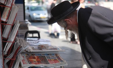 Man reads newspapers in Jerusalem.