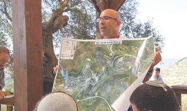 Koby Elraz shows map of his settlement