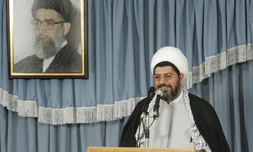 Ali Shirazi speaks under picture of Ayatollah.