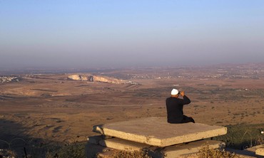 Druse resident looks out at Syria from the Golan -Photo: Ronen Zvulun/Reuters