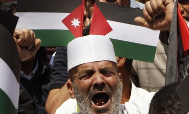Man yells in front of Palestinian, Jordanian flags -Photo: REUTERS/Ali Jarekji