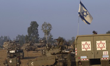 IDF tanks and a flag on the Gaza border
