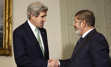 US Secretary of State John Kerry (L) shakes hands with Egypt's President Mohamed Morsi in Cairo