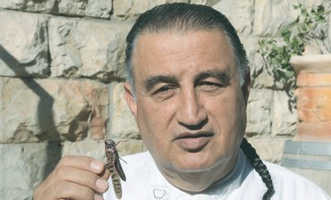 CHEF MOSHE BASSON holds a locust March 10, 2013 outside his Eucalyptus Restaurant in the capital