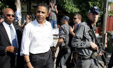 US President Barack Obama is escorted by an Israeli police officer in Sderot July 23, 2008