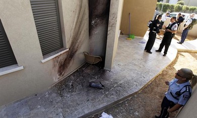 A policewoman looks at the damage after a rocket fired from Gaza lands in Sderot, March 21, 2013