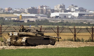 IDF soldier sits atop a tank just outside northern Gaza