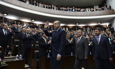 Turkish Prime Minister Erdogan waves at his parliament.