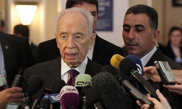 Shimon Peres talks to reporters at the World Economic Forum in Jordan, May 26, 2013.