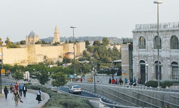 THE OLD CITY walls in east Jerusalem contrast against the modern buildings in west Jerusalem