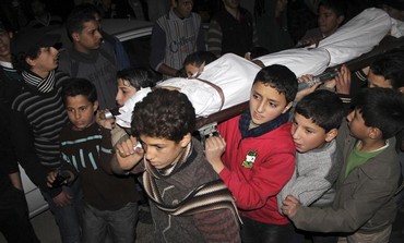 Children carry the body of a friend that was killed by shelling 