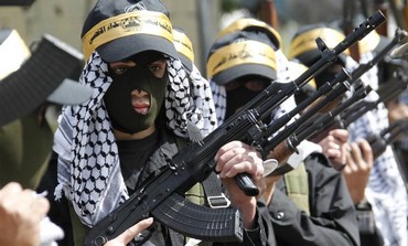 Palestinian Fatah members carry their weapons as they take part in a parade.
