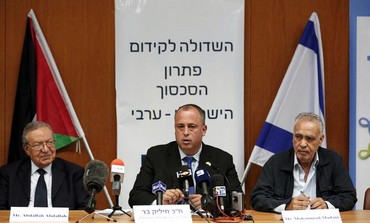Israeli member of parliament Hilik Bar (C) sits next to Abdullah Abdullah (L).