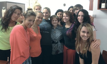Holocaust survivor Leah Kaufman poses with students after delivering lecture about her past.