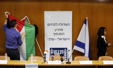 Israeli parliament employees set up a Palestinian flag (L) next to an Israeli ahead of peace talks