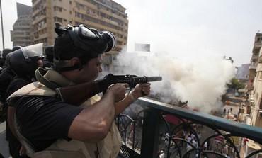 Riot police fire tear gas during clashes with Morsi supporters in Cairo, August 14