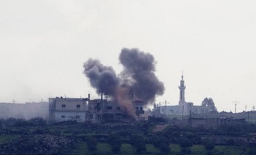Smoke rises from shell explosions in the Syrian village of al-Jamlah.