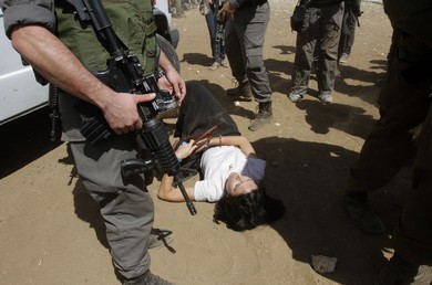 French diplomat Marion Castaing lays on the ground after Israeli soldiers carried her out of her truck (Reuters)