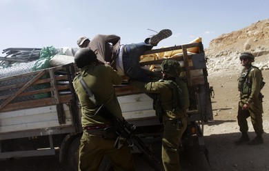 IDF soldiers pull a Palestinian off a truck loaded with items European diplomats wanted to deliver to locals in the West Bank (Reuters)