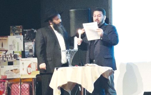 UKRAINIAN MP Evgeni Geller lights the hanukkia as Shaul Melamed looks on at a gathering of former me
