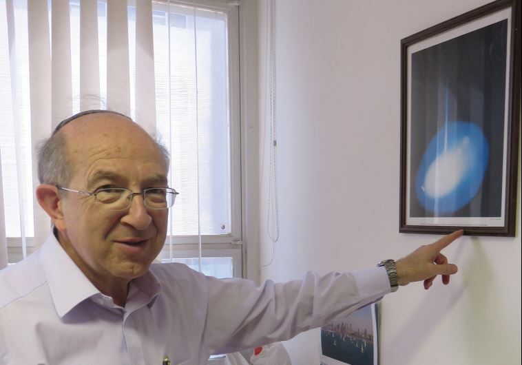 DR. YEHEZKEL CAINE points to a Gemini mission photo given to him by NASA.