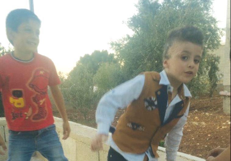 FIREBOMBING SURVIVOR Ahmad Dawabsha plays with his cousins outside their Duma home yesterday.