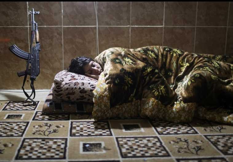 A female Kurdistan Workers Party (PKK) fighter sleeps at a base in Sinjar
