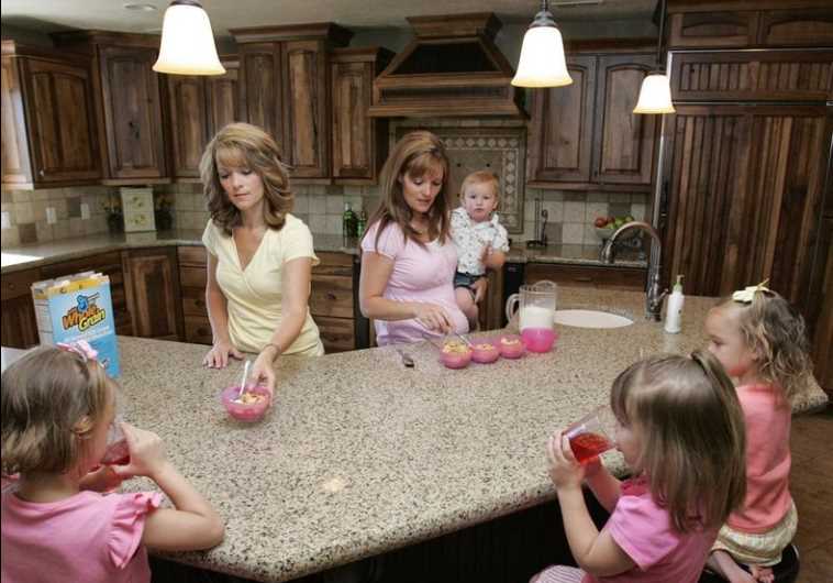 Sister-wives Valerie (L) and Vicki serve breakfast to their children in their polygamous house