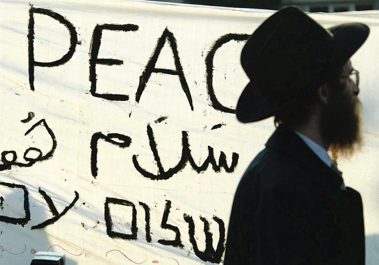 A jewish man passes a banner which reads ‘Peace Now’ during a pro-Israel demonstration