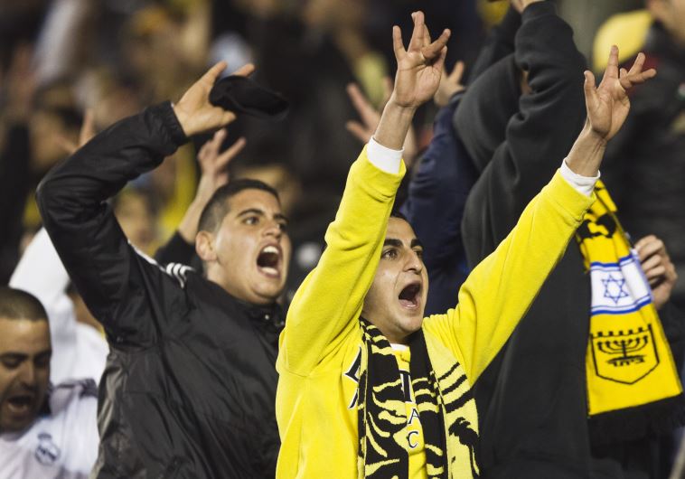 Fans of Beitar Jerusalem shout slogans during a match against Bnei Sakhnin
