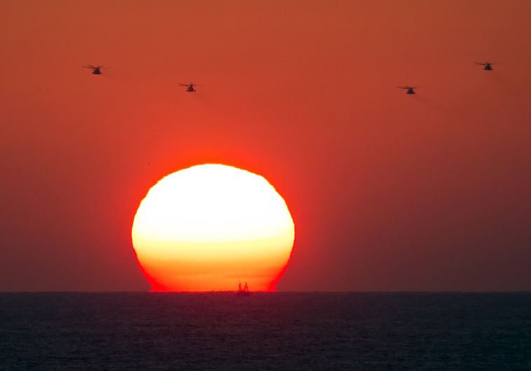 Four military helicopters fly over the Mediterranean sea opposite the port of Ashdod