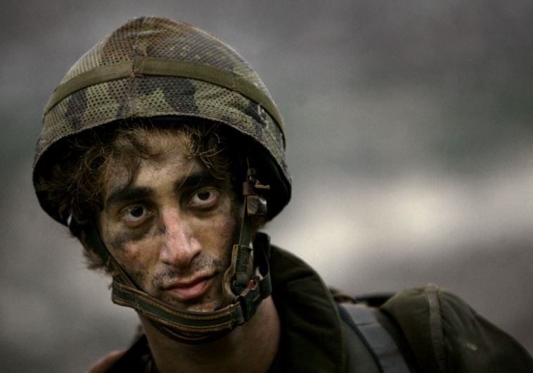 An Israeli soldier walks as leaves Lebanese territory during the second day of a ceasefire