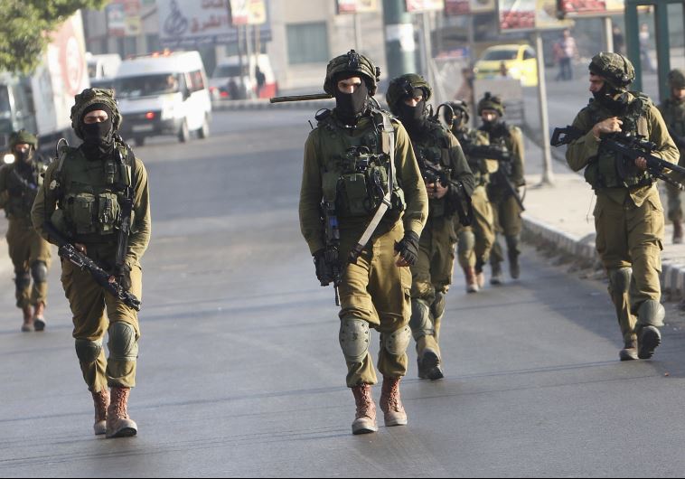 IDF soldiers take up positions during clashes with Palestinian youths in Nablus
