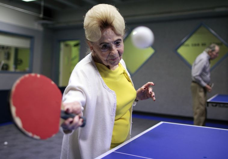 Holocaust survivor Betty Stein, 92, (L) and Eli Boyer, 91, play ping pong