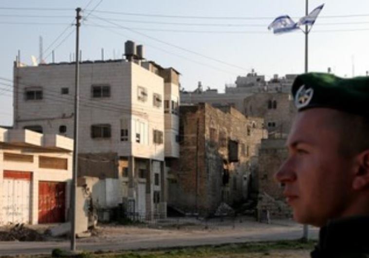 IDF soldier stands guard next to Beit Hamachpela