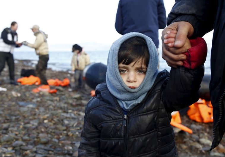 A Syrian refugee child looks on, moments after arriving on a raft with other Syrian refugees