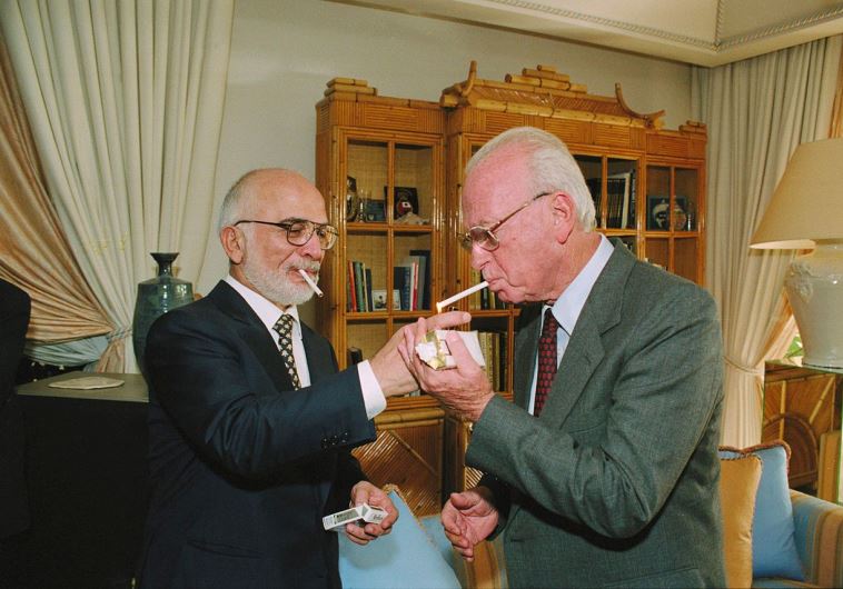 Jordan's late King Hussein (L) offers then-premier Yitzhak Rabin a cigarette at his palace in Aqaba