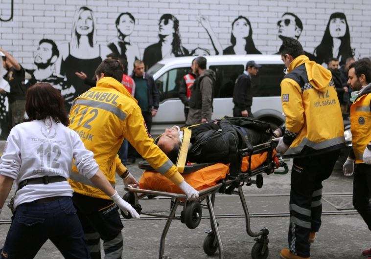 A man is helped by emergency services following a suicide bombing in Istanbul