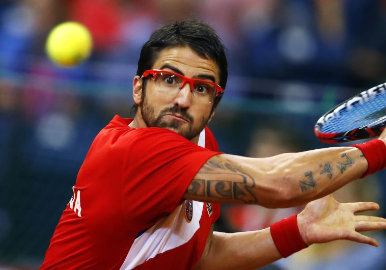 Serbia's Janko Tipsarevic returns the ball to Canada's Vasek Pospisil during their Davis Cup semi-fi