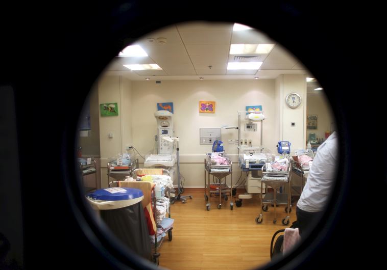 Cribs for newborn babies are seen through an window at a nursery in a hospital in Jerusalem, Septemb