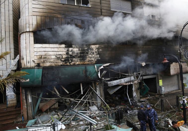 PA POLICEMEN stand in front of shops in El-Bireh, adjacent to Ramallah, after a fire that IDF troop 