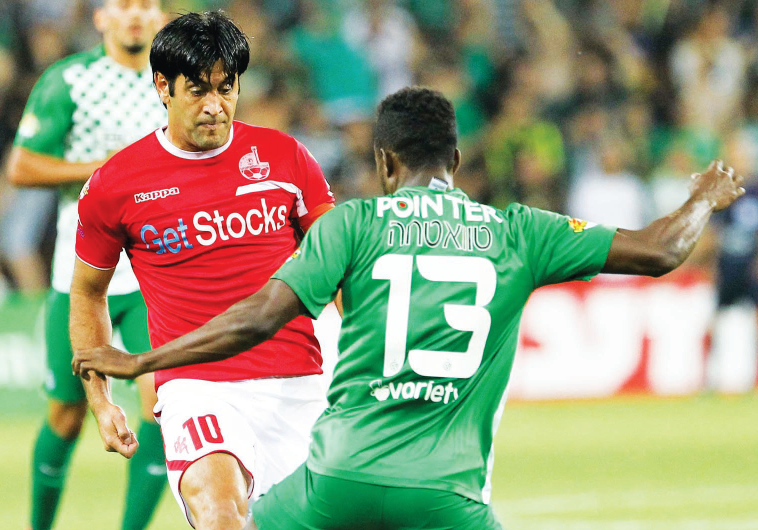 Hapoel Beersheba striker Elyaniv Barda (in red) and Maccabi Haifa defender Taleb Tawatha (13) are se