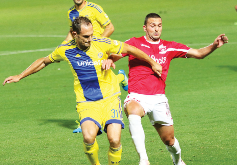 Maccabi Tel Aviv defender Carlos Garcia (left) and Hapoel Beersheba striker Ben Sahar battle for the
