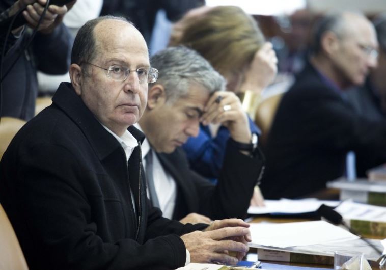 Defense Minister Moshe Ya'alon (L) looks on during a cabinet meeting in Jerusalem