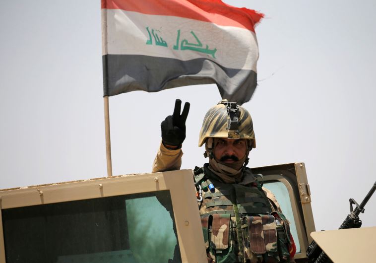 An Iraq soldier gestures near Falluja, Iraq