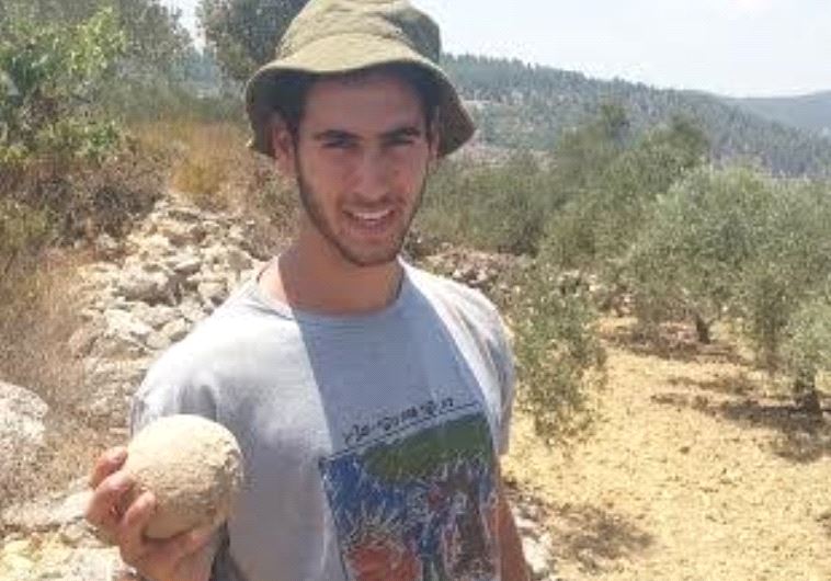 A student from the Kfar Etzion Field School holds a stone ballista ball used during the legendary Ba